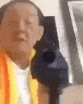 a man in a yellow vest is holding a gun in his hand .