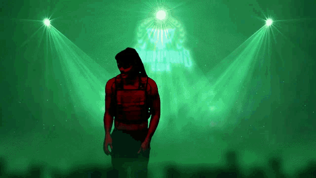 a man in a red vest is standing in front of a green background with the word champions written in blue