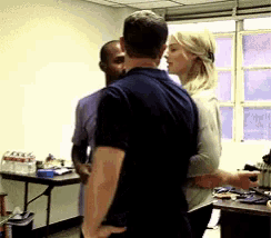 a man and woman are hugging in a room