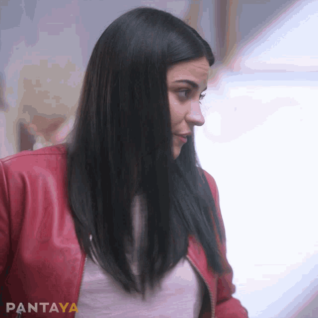 a woman wearing a red leather jacket and a white shirt with pantaya written on it