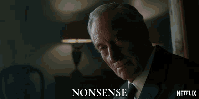 a man in a suit is looking down with the word nonsense behind him