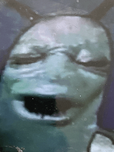 a close up of a person 's face with their eyes closed and mouth open