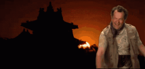 a man is holding a torch in front of a fire