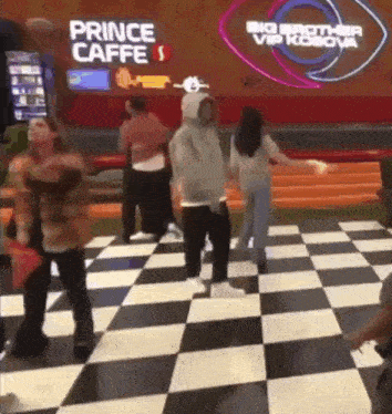 a group of people are dancing in front of a sign that says prince caffe