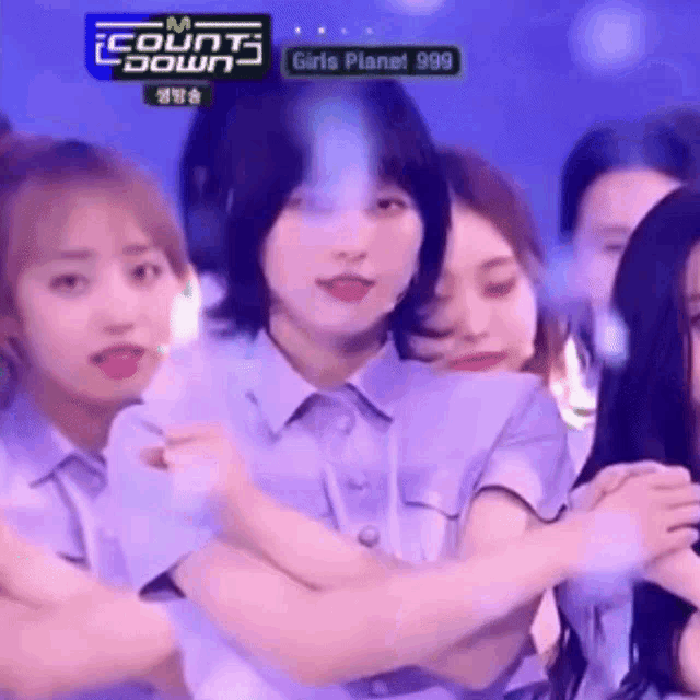 a group of girls are standing next to each other on a stage in a room .