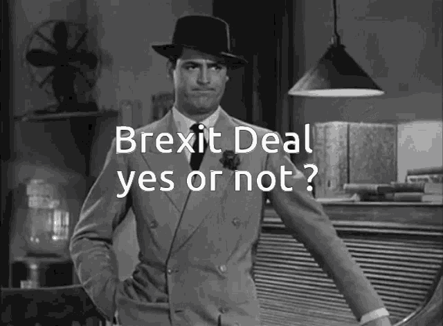 a man in a suit and hat stands in front of the words brexit deal yes or not