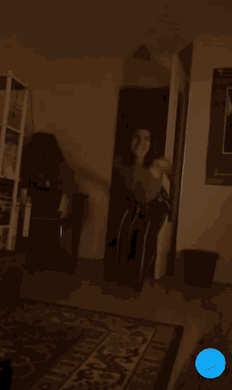a blurry picture of a woman standing in a doorway with a blue arrow pointing to the right