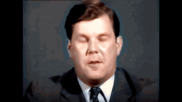 a man in a suit and tie is making a funny face