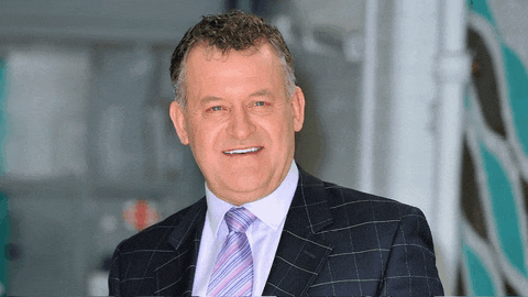 a man wearing a suit and tie is smiling for the camera