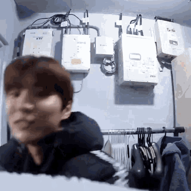 a man laying on a bed in front of a wall with boxes on it that say ktf
