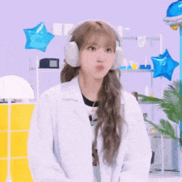 a woman wearing headphones and a lab coat is making a face .