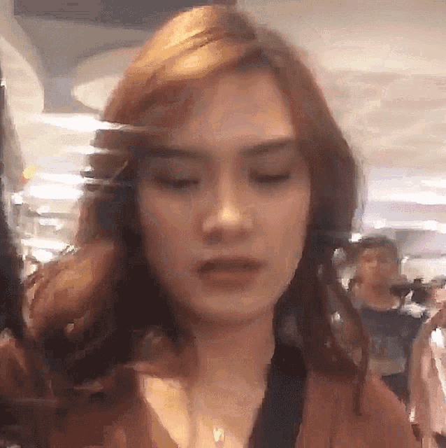 a blurry picture of a woman 's face with a reflection of a person in the background