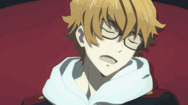 a boy with glasses is laying on a red chair