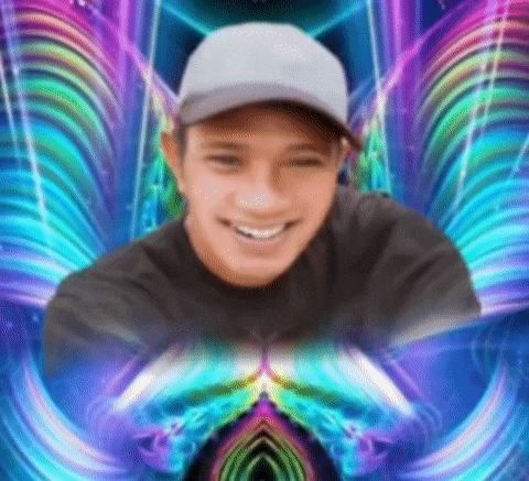 a man wearing a baseball cap and a black shirt is smiling in front of a colorful background .