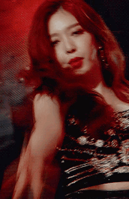 a woman with red hair wearing a black top
