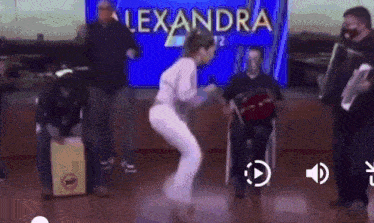 a group of people are dancing in front of a screen that says alexandra on it