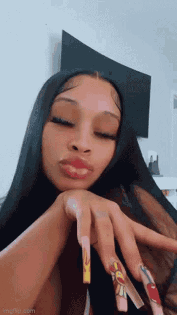 a woman with long black hair and very long nails is making a face .