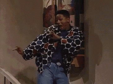 a man in a polka dot jacket is standing on a set of stairs next to a painting .