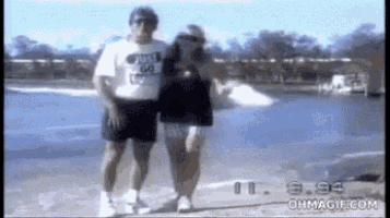 a man wearing a shirt that says just 64 is walking with a woman