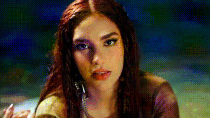 a close up of a woman 's face with red hair and a necklace .