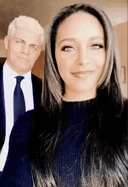 a man in a suit and tie is standing next to a woman