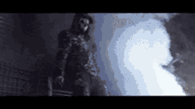a silhouette of a person with a mask on standing in the dark