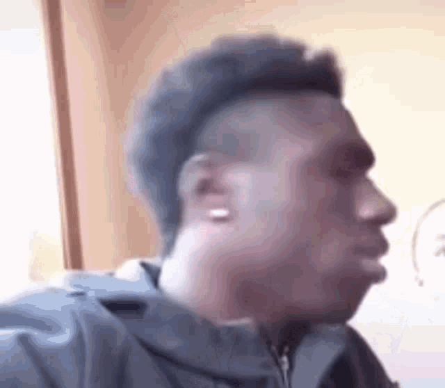 a man with a mohawk is making a funny face and looking at the camera .