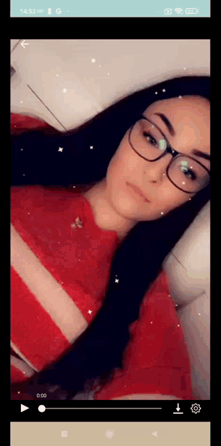 a woman wearing glasses and a red shirt is on a cell phone screen
