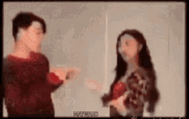 a man and a woman are talking to each other in a room .