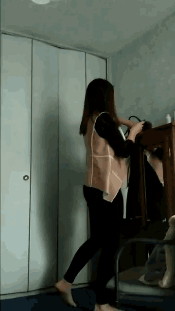 a woman is standing in front of a closet holding a purse