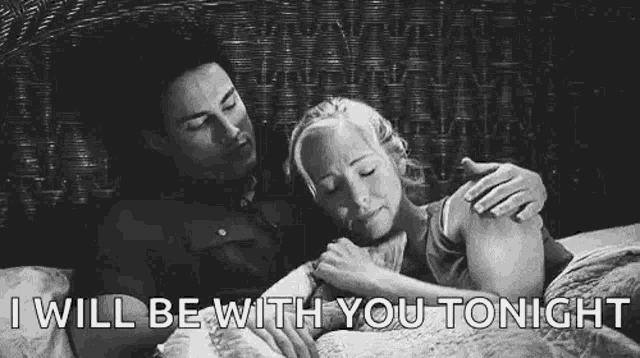 a man and a woman are laying in bed hugging each other .