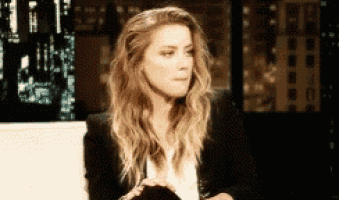a woman with long blonde hair is sitting in front of a computer screen .