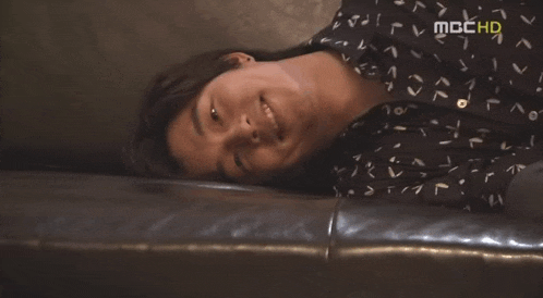 a man is laying on a couch with a mbc hd logo on the bottom