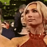 a woman in a red dress is standing in a crowd .