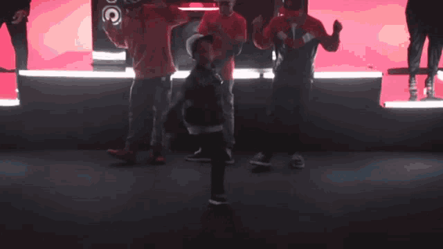 a group of people in red shirts are standing around a ball