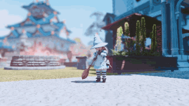 a little girl in a witch costume is holding a broom in front of a building