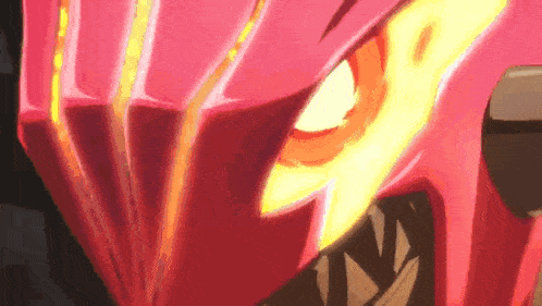 a close up of a red helmet with a yellow eye and teeth .