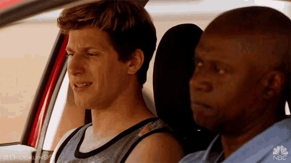 two men are sitting in a car with the nbc logo on the bottom right