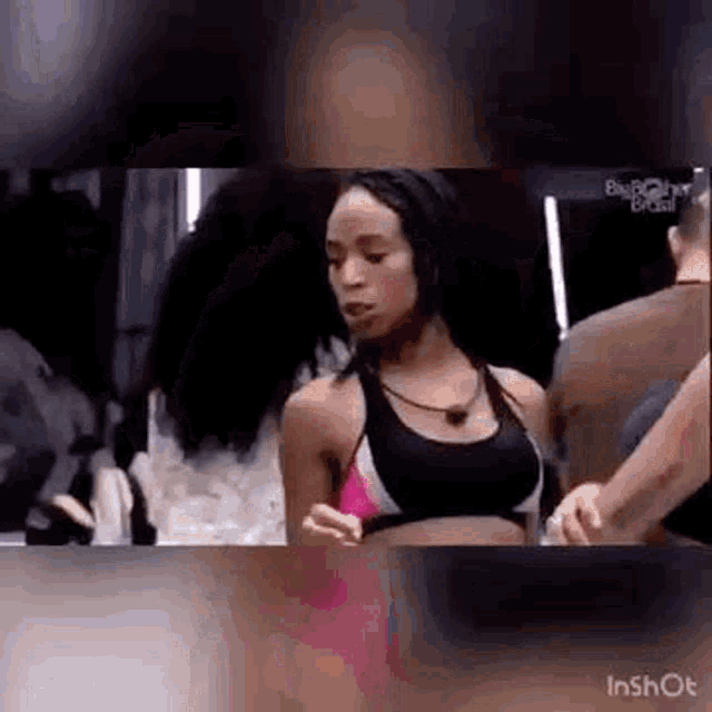 a woman in a sports bra is standing next to a group of people .