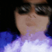 a close up of a person smoking a cigarette with purple smoke coming out of their mouth