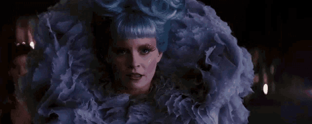 a woman with blue hair is wearing a purple dress and a purple wig .