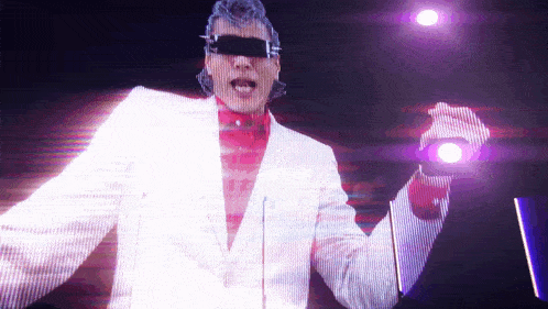 a man in a white suit and sunglasses is holding a purple light