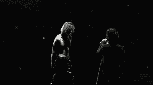 a black and white photo of a man without a shirt on dancing on a stage .