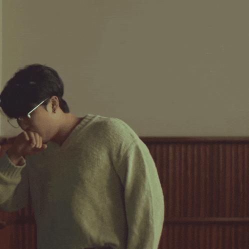 a man wearing glasses and a sweater with a light on his head