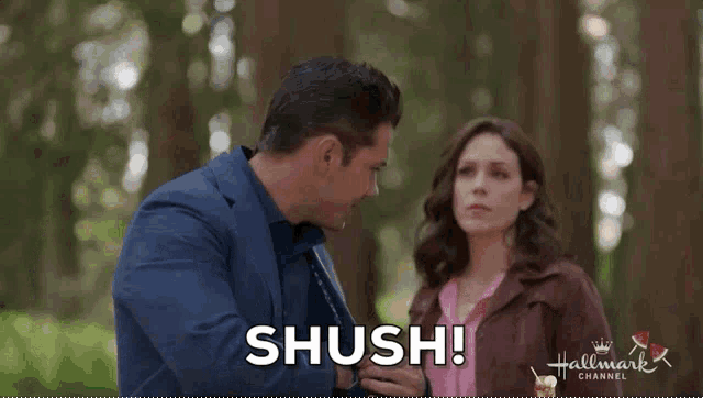 a man and a woman are standing next to each other and the man says shush