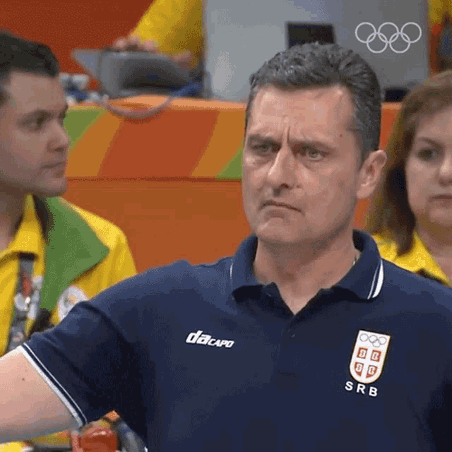 a man wearing a blue shirt with srb on the front