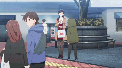 a group of people are standing on a sidewalk with a woman holding a heart shaped bag