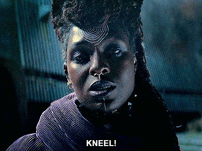 a woman with dreadlocks and a nose ring is kneeling down
