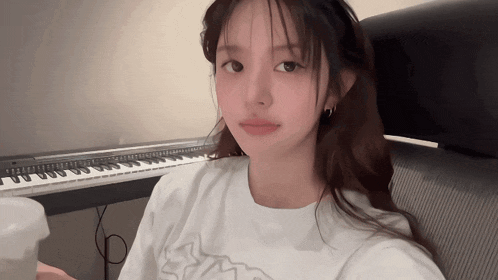 a woman sitting in front of a piano keyboard