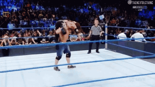 two men are wrestling in a wrestling ring with a referee watching ..